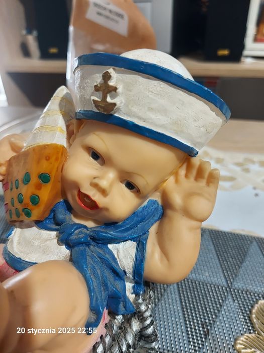 Figurka dekoracyjna chłopiec w marynarskiej czapce z łódką na plaży