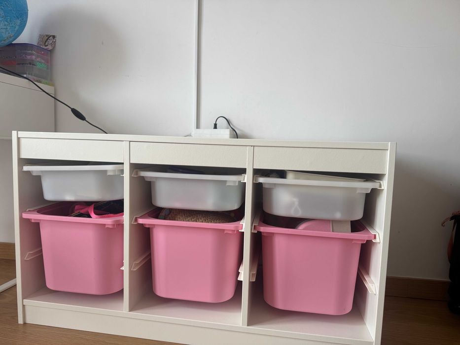 Cómoda para brinquedos branco e rosa.