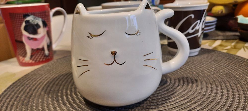 Biały złocony kubek kotek