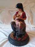 Estatueta de mãe a amamentar bebé
