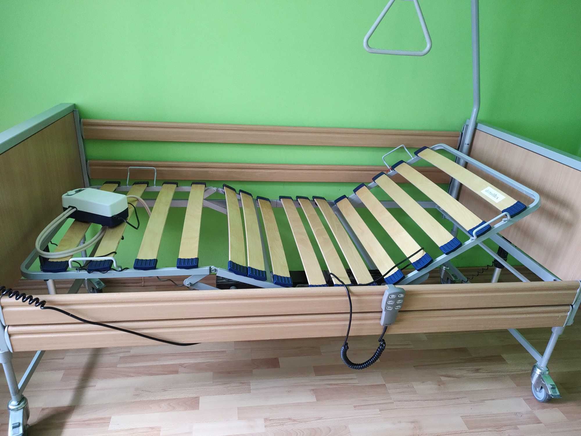 Łóżko rehabilitacyjne elektryczne z wózkiem inwalidzkim i chodzikiem.