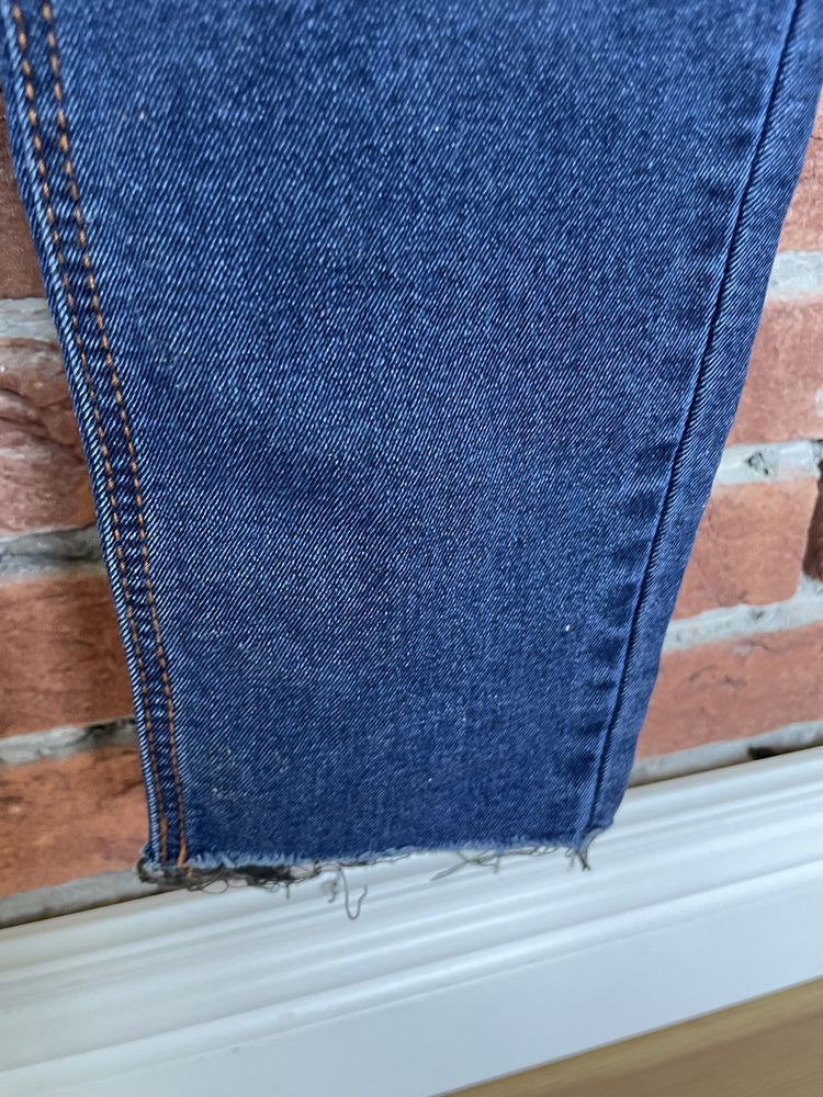 Niebieskie spodnie Pull & Bear w roz. 36 z rozdarciami na kolanach.