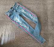 Damskie jeansy z podartymi nogawkami. Niebieskie jeansy z przetarciami