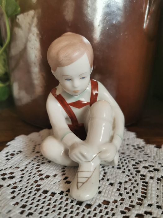 Figurka chłopca wiążącego bucik