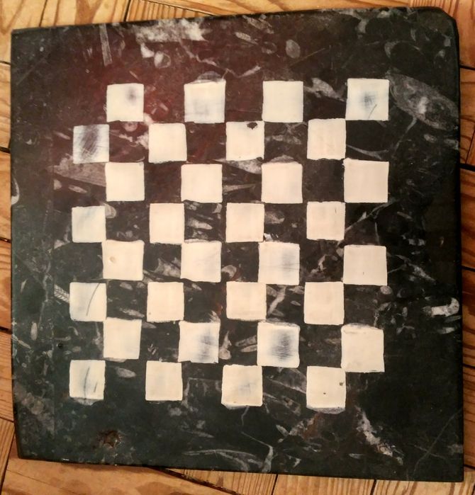 Tabuleiro de xadrez e damas em pedra.