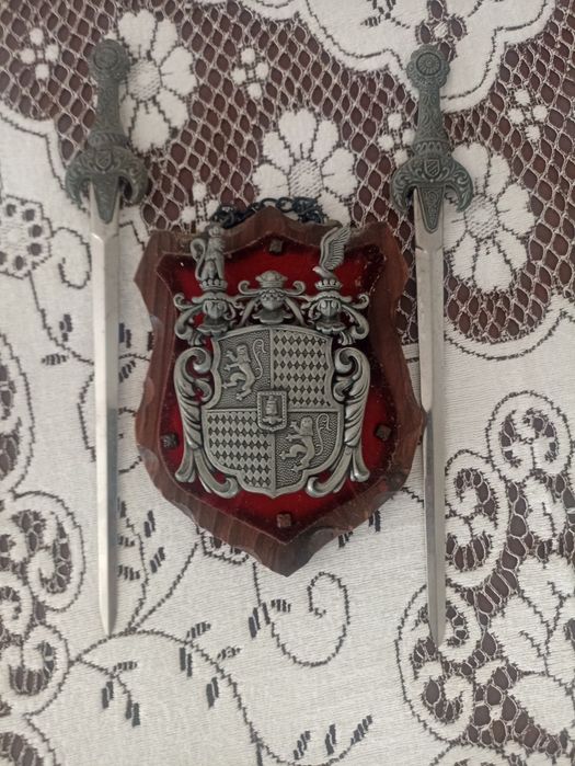 Brasão decorativo com duas espadas metálicas