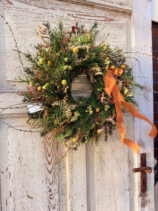 Jesienny wianek z gałązkami modrzewia i pomarańczową kokardą