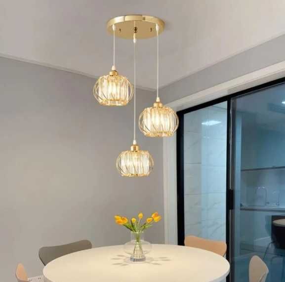 Lampa wisząca z 3 jasnymi złotymi kryształami.