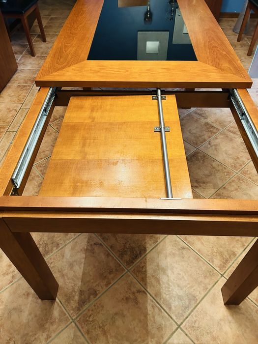 Mesa extencível em cerejera, composta por 8 cadeiras em polipel pretas