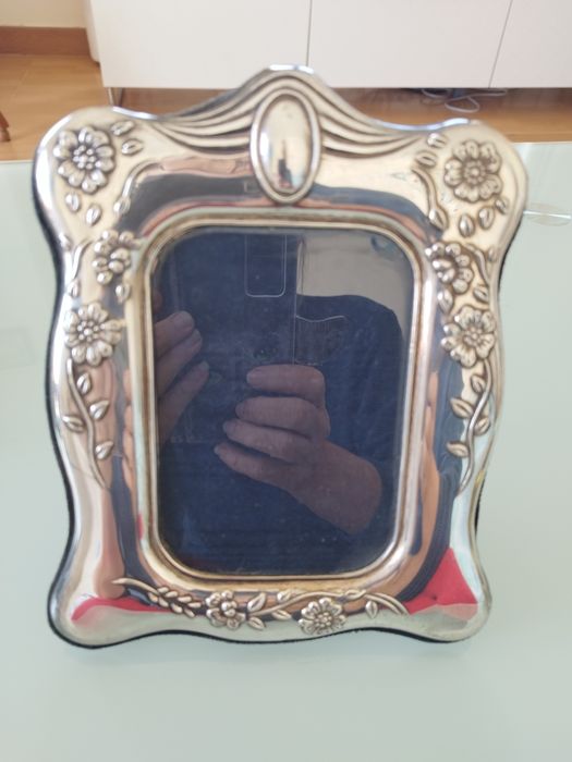 Moldura delicada com detalhes florais em relevo.

- Material: Prata
-