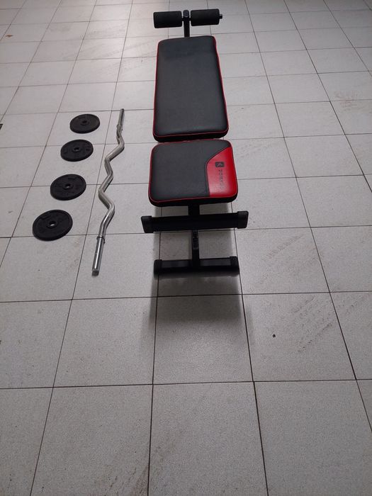 Bancada de musculação, barra e alguns discos