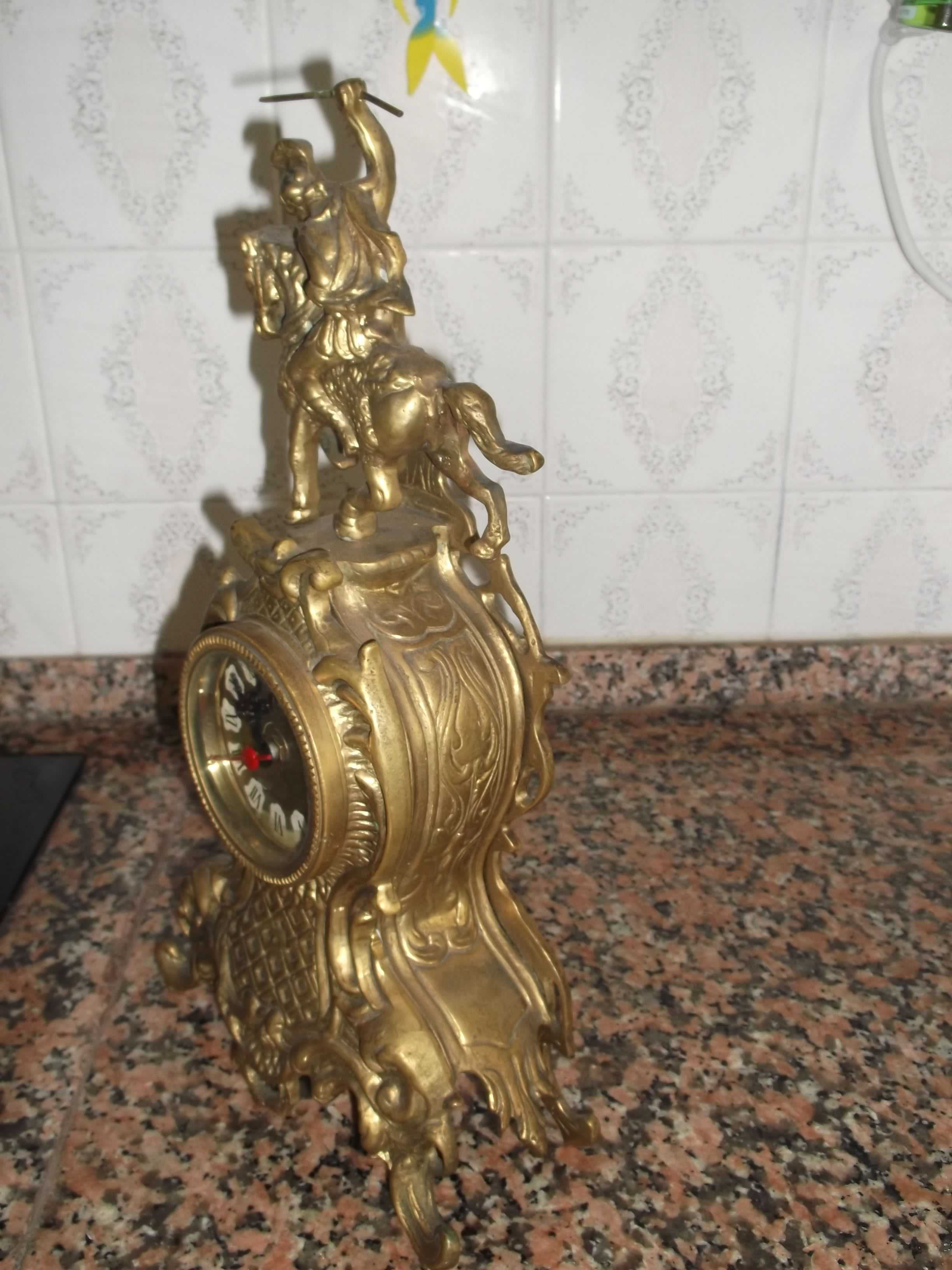 Relógio e cavaleiro em metal.