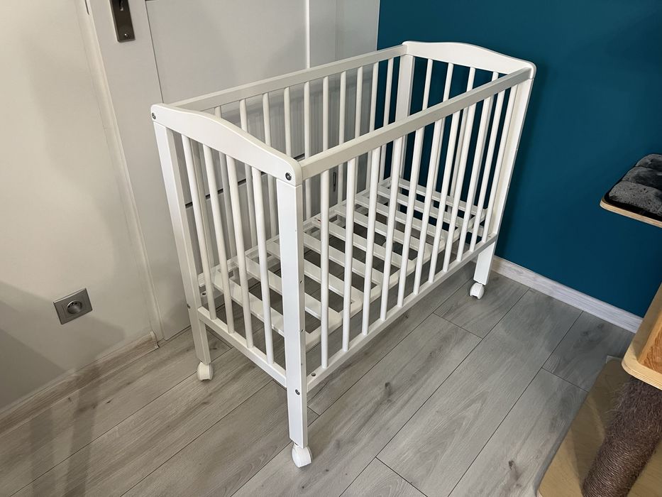 Małe łóżeczko dziecięce niemowlęce drewniane na kółkach z materacem