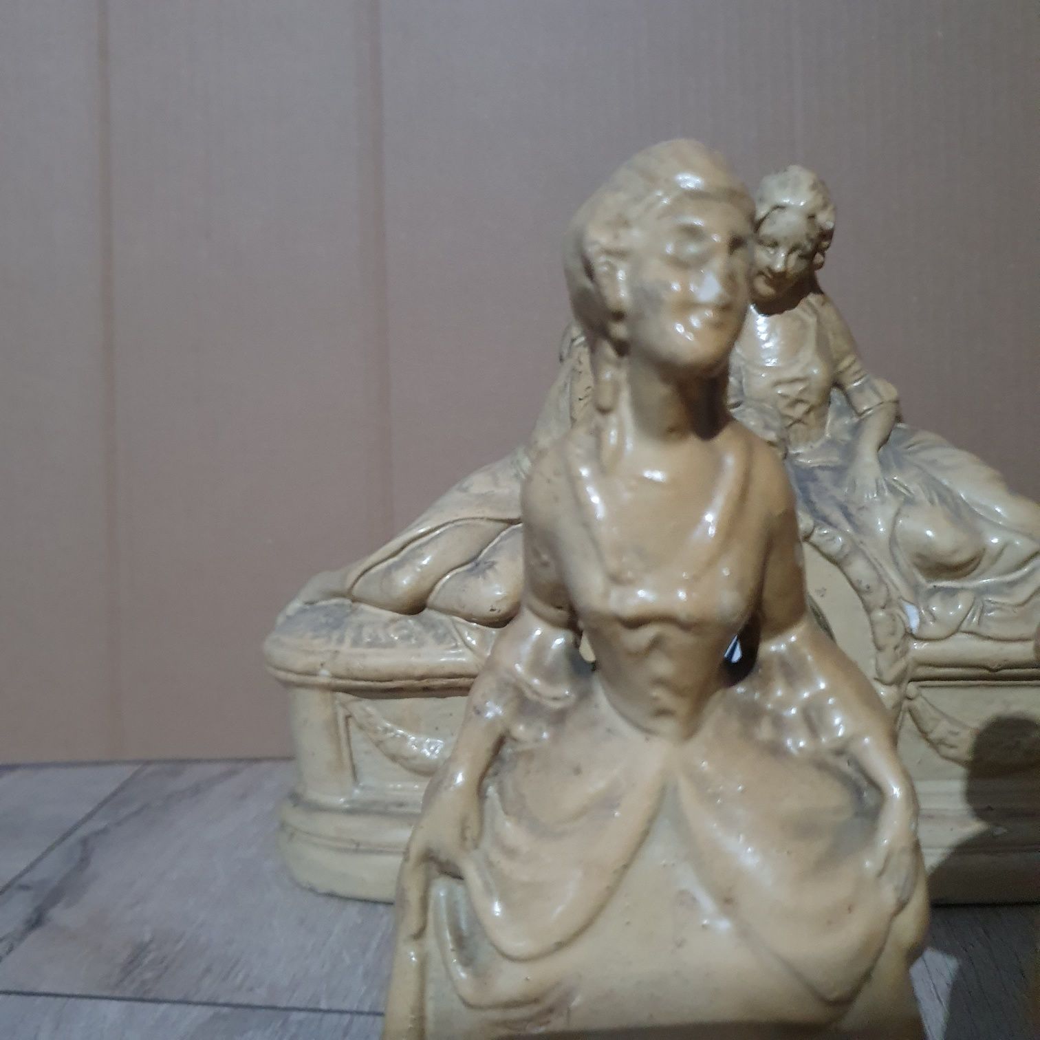 Stary ceramiczny zegar z dwoma figurkami.