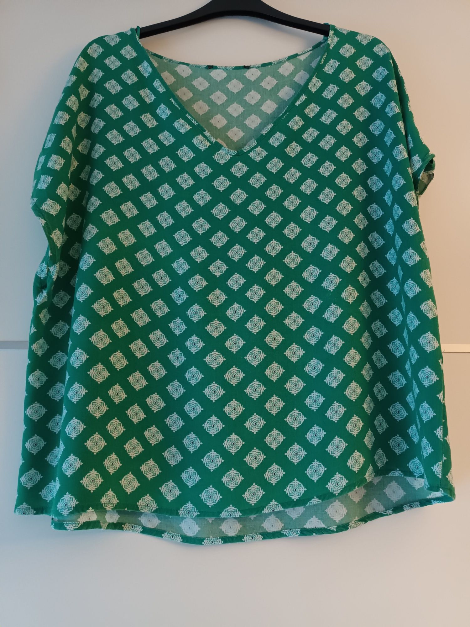 Blusa verde com padrão de flores brancas