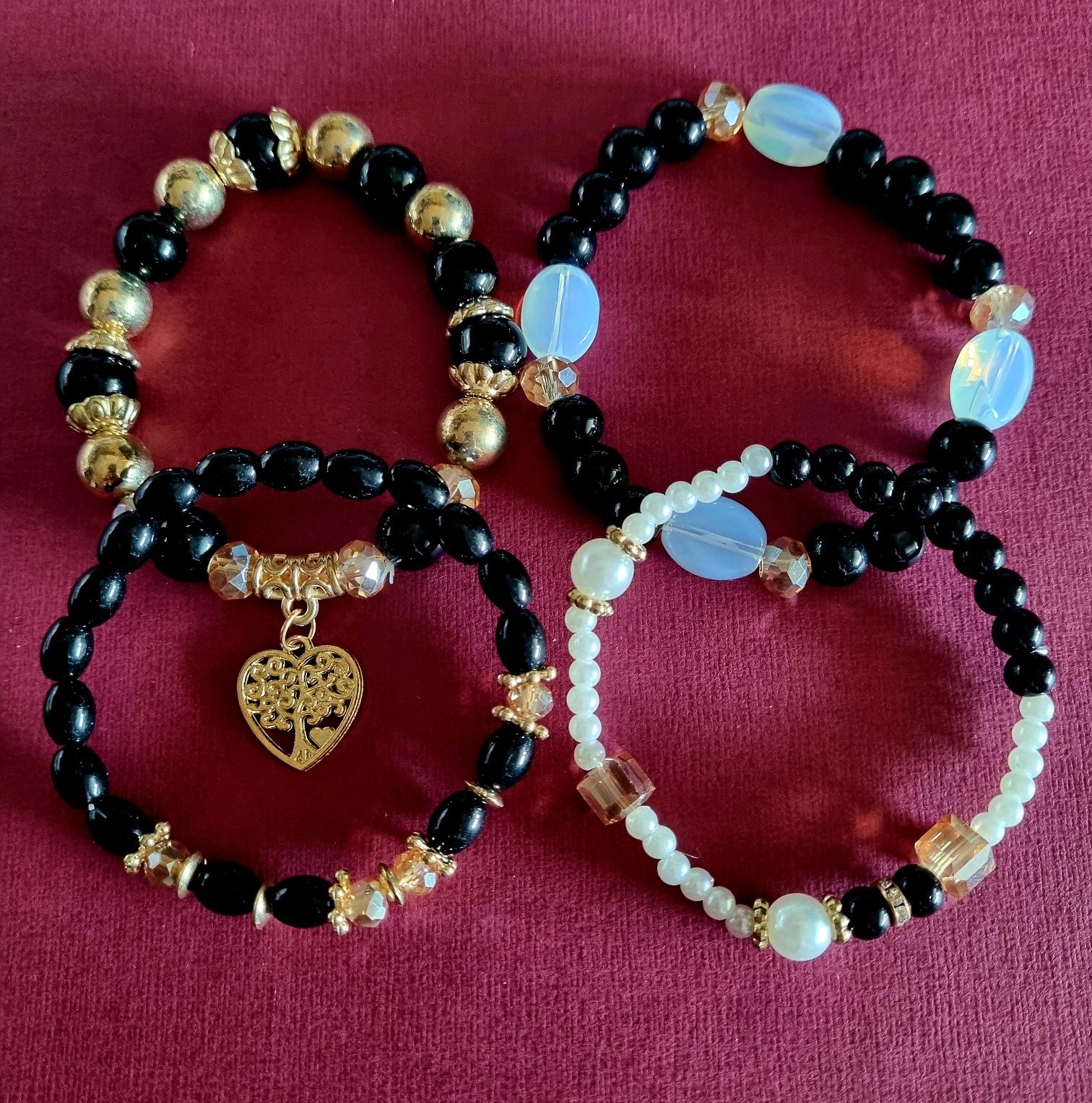 Conjunto de 4 pulseiras elásticas em tons de preto e dourado.
