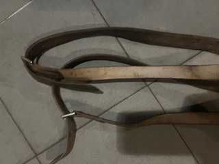 Um par de estribos metálicos com suspensões em couro