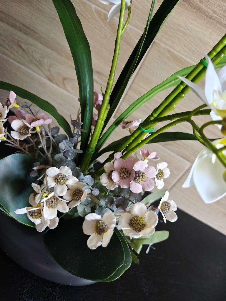 Sztuczny storczyk orchidea w czarnej ceramicznej doniczce