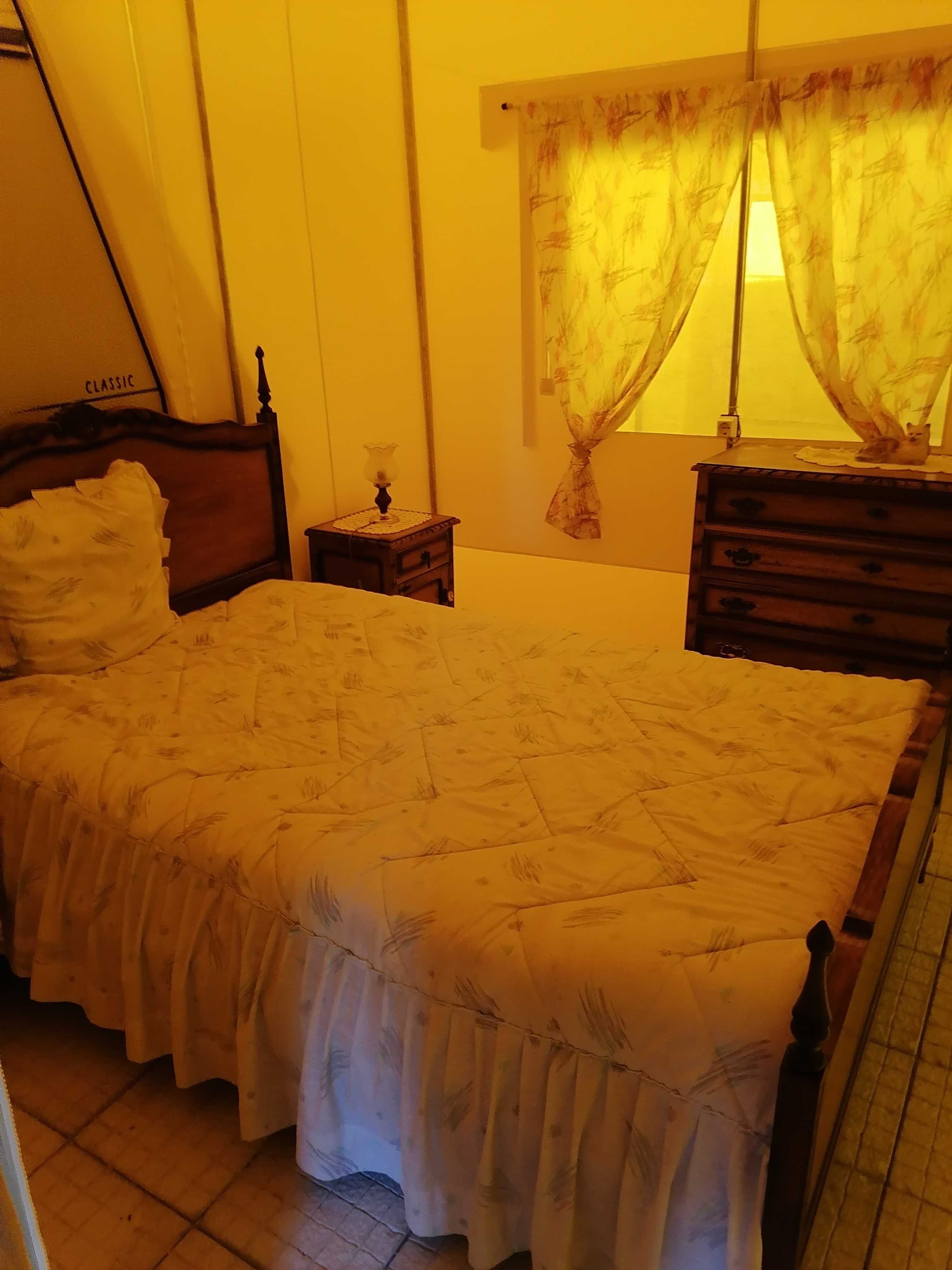 Cama com colchão e mesa de cabeceira