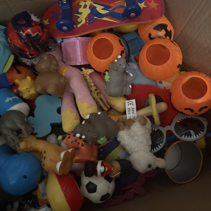 На изображении показана коробка, наполненная разнообразными игрушками.