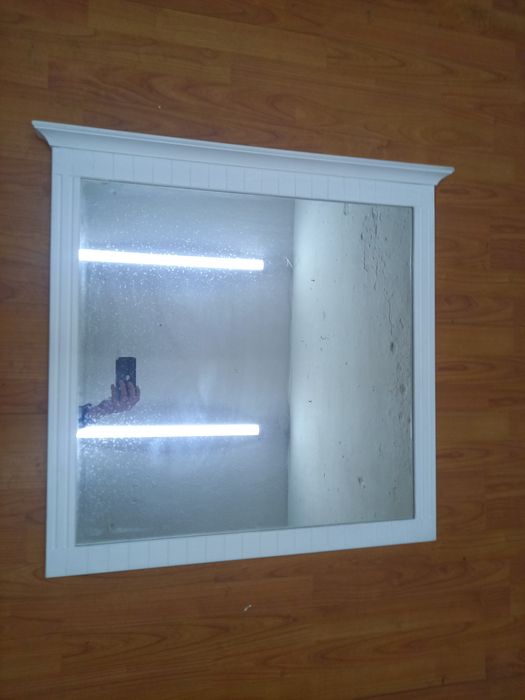 Lustro w drewnianej ramie.