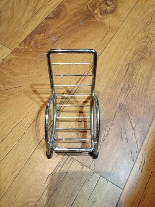 Metalowy stojak na dawny telefon komórkowy.