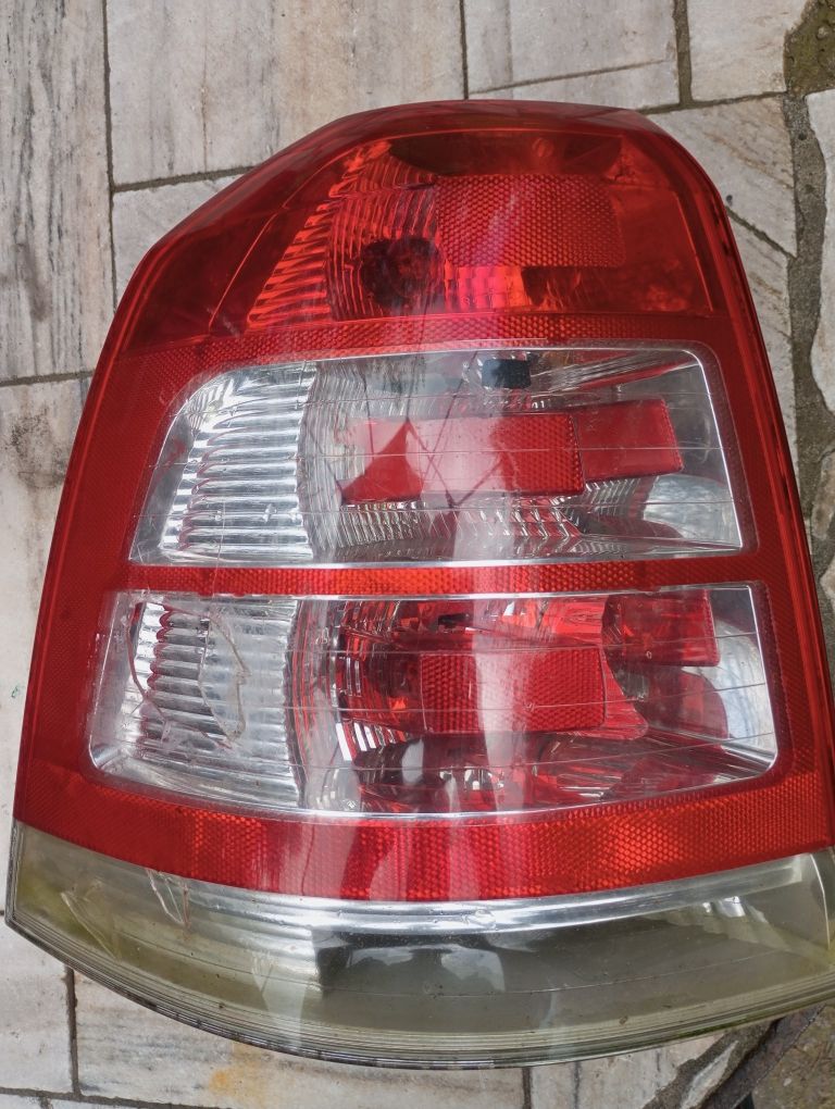 Lampa tylna Zafira B lewa z panelem posiada żarówki i nakrętki