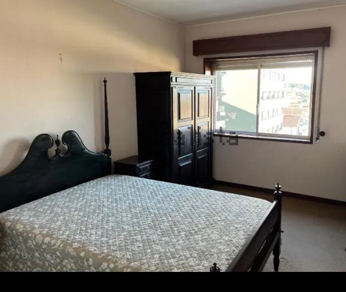 Cama de casal com duas mesas de cabeceira em castanho.