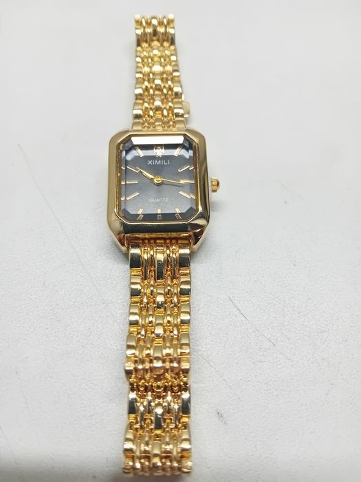 Relogio preto pulseira dourada