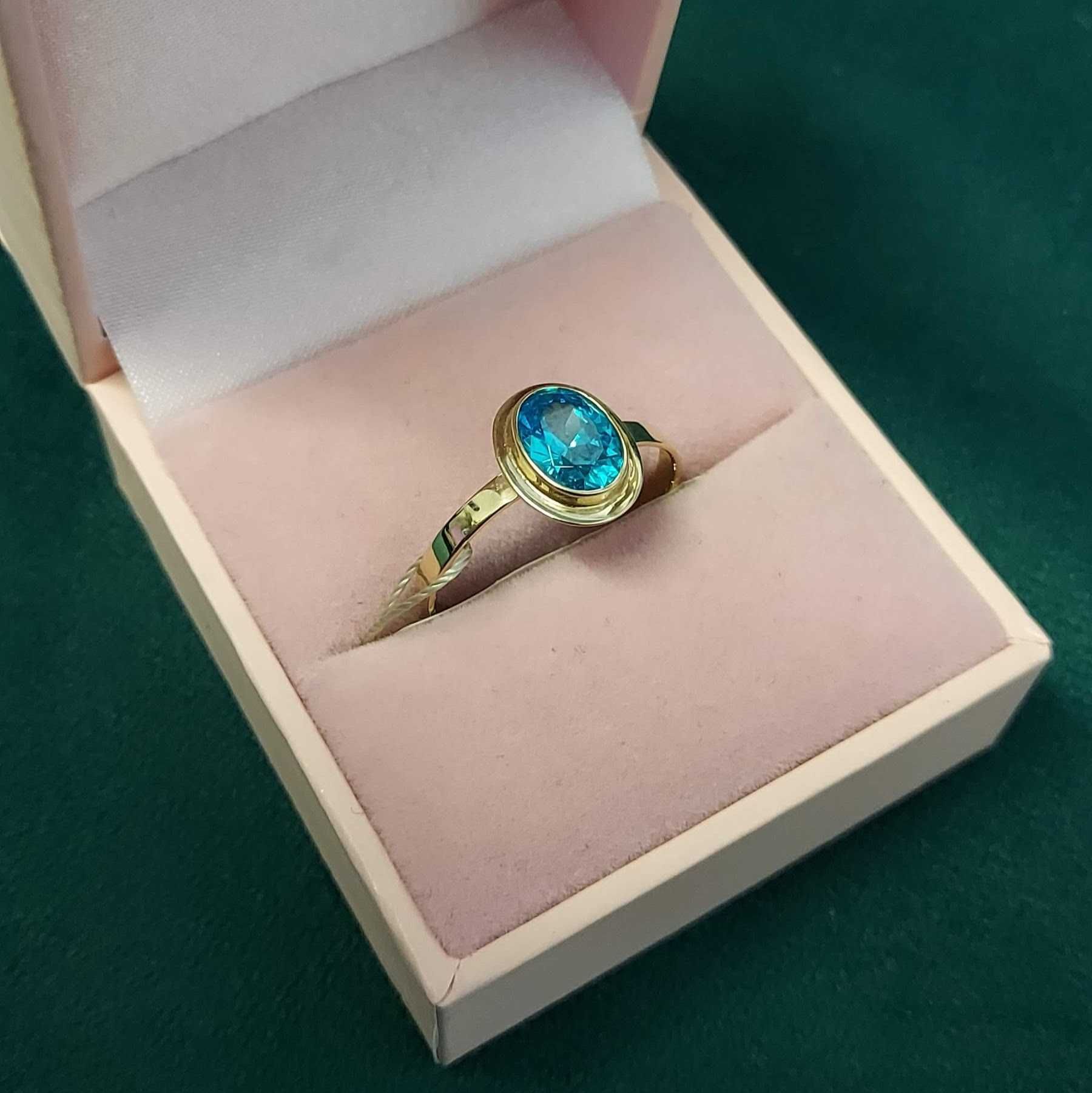 Złoty pierścionek z niebieskim kamieniem
