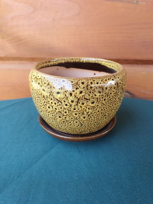 Żółta doniczka ceramiczna z przytwierdzoną podstawką