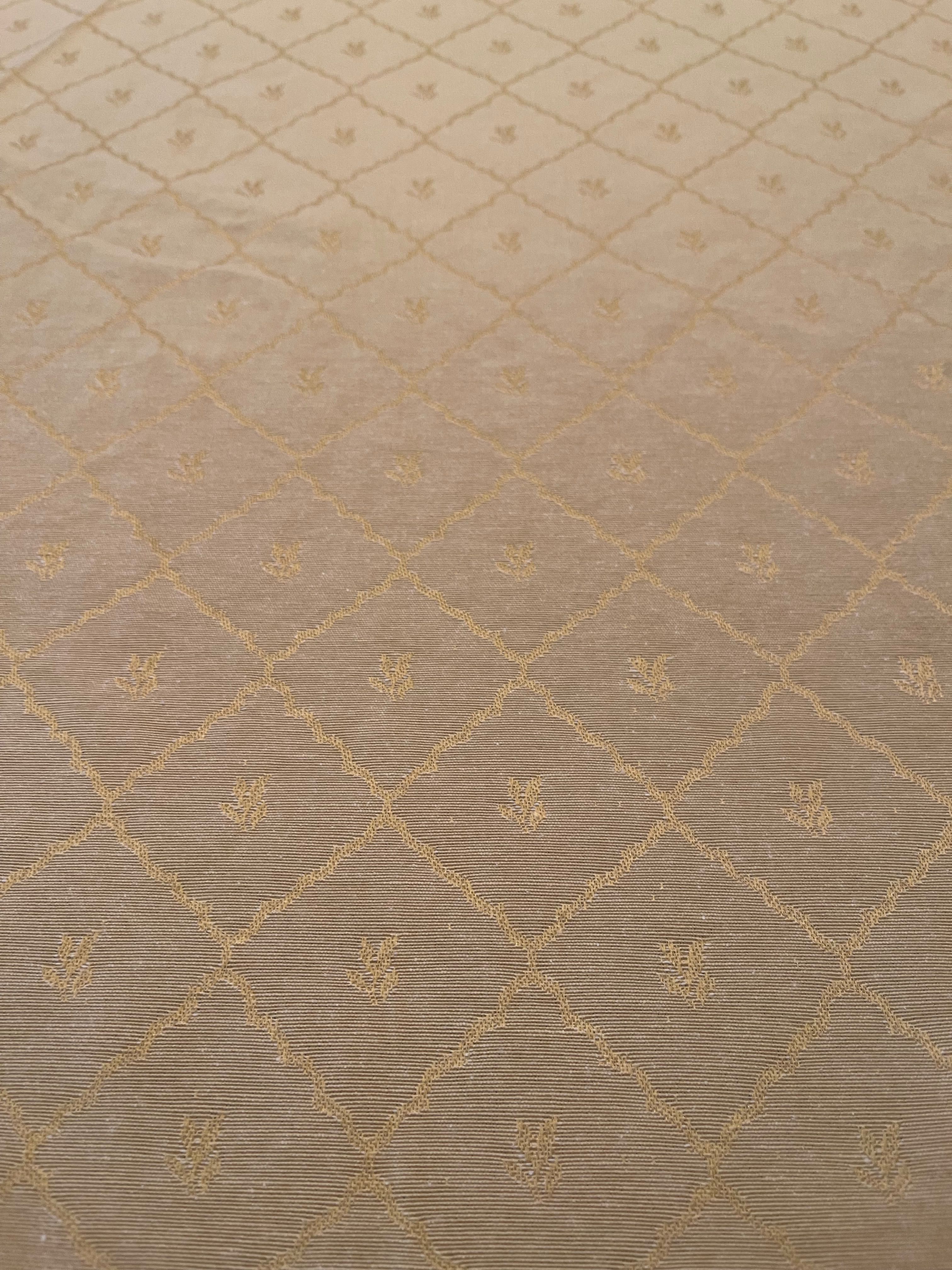 Toalha de mesa redonda em tom creme com detalhes dourados