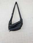Bolsa de cintura em couro preto e fechos múltiplos.