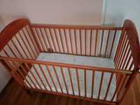 Drewniane brązowe łóżeczko dziecięce z materacem