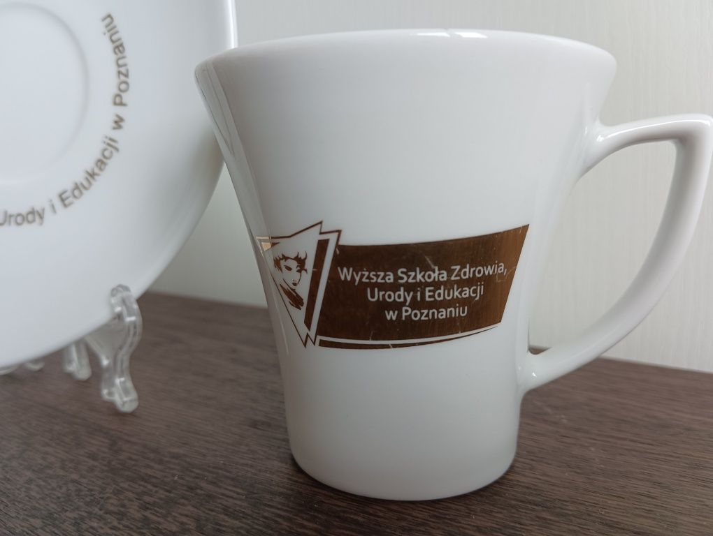 Filiżanka ze spodkiem. Logo Wyższa szkoła kosmetologii Anieli Goc