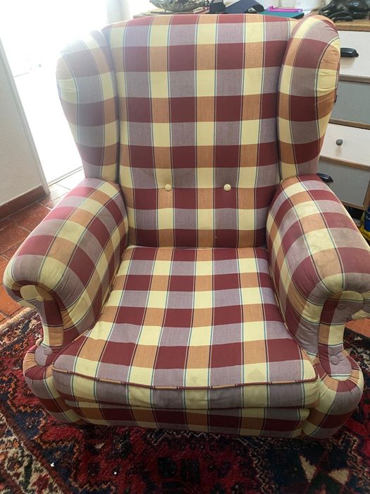 Poltrona vintage de orelhas com estampa xadrez.