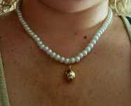 Colar de pérolas com acabamento e pingente em forma de gota, em aço.