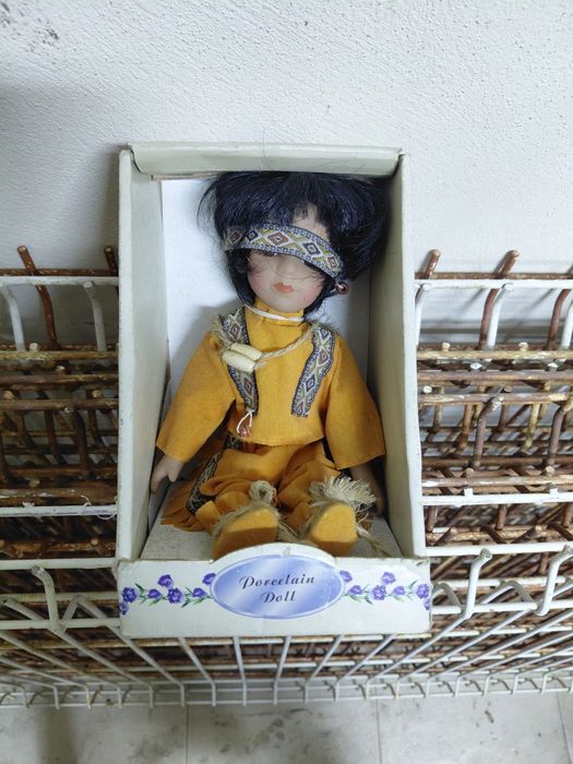 Boneca antiga de porcelana no estado real que se encontra nas fotos
