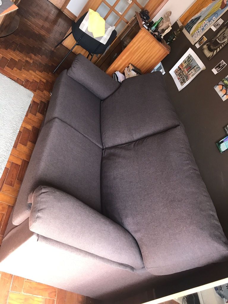 Sofá em tecido 2 lugares espaçoso com almofadas decorativas.