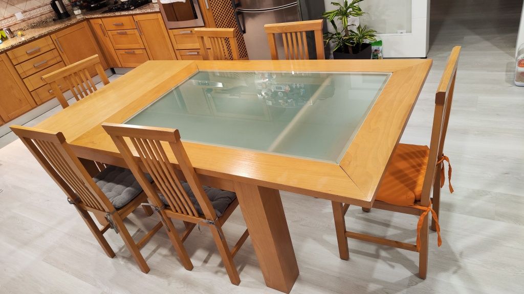 Mesa em madeira e vidro com 8 cadeiras.