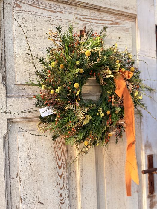 Jesienny wianek z gałązkami modrzewia i pomarańczową kokardą