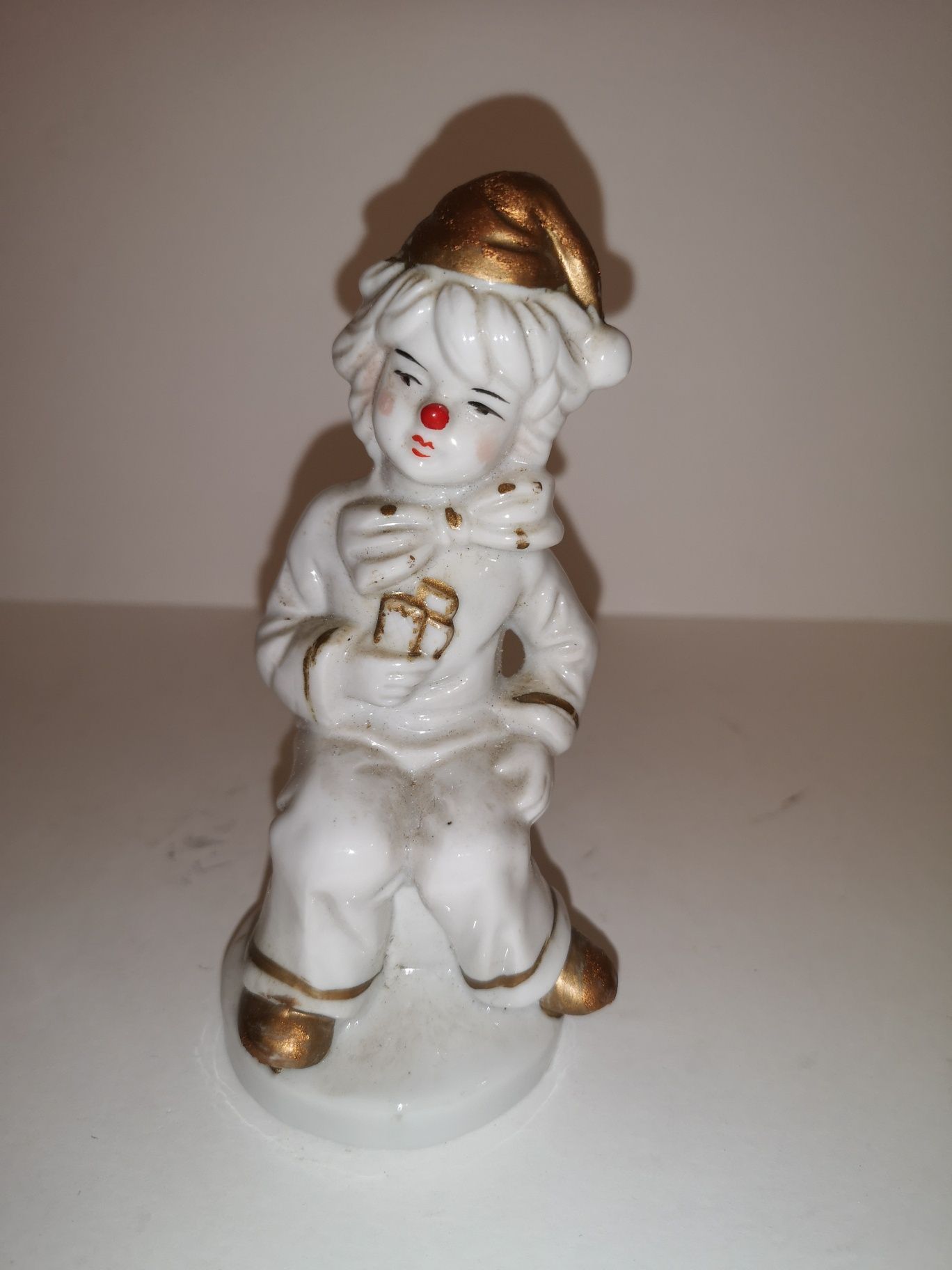 Porcelanowa figurka siedzącego klauna