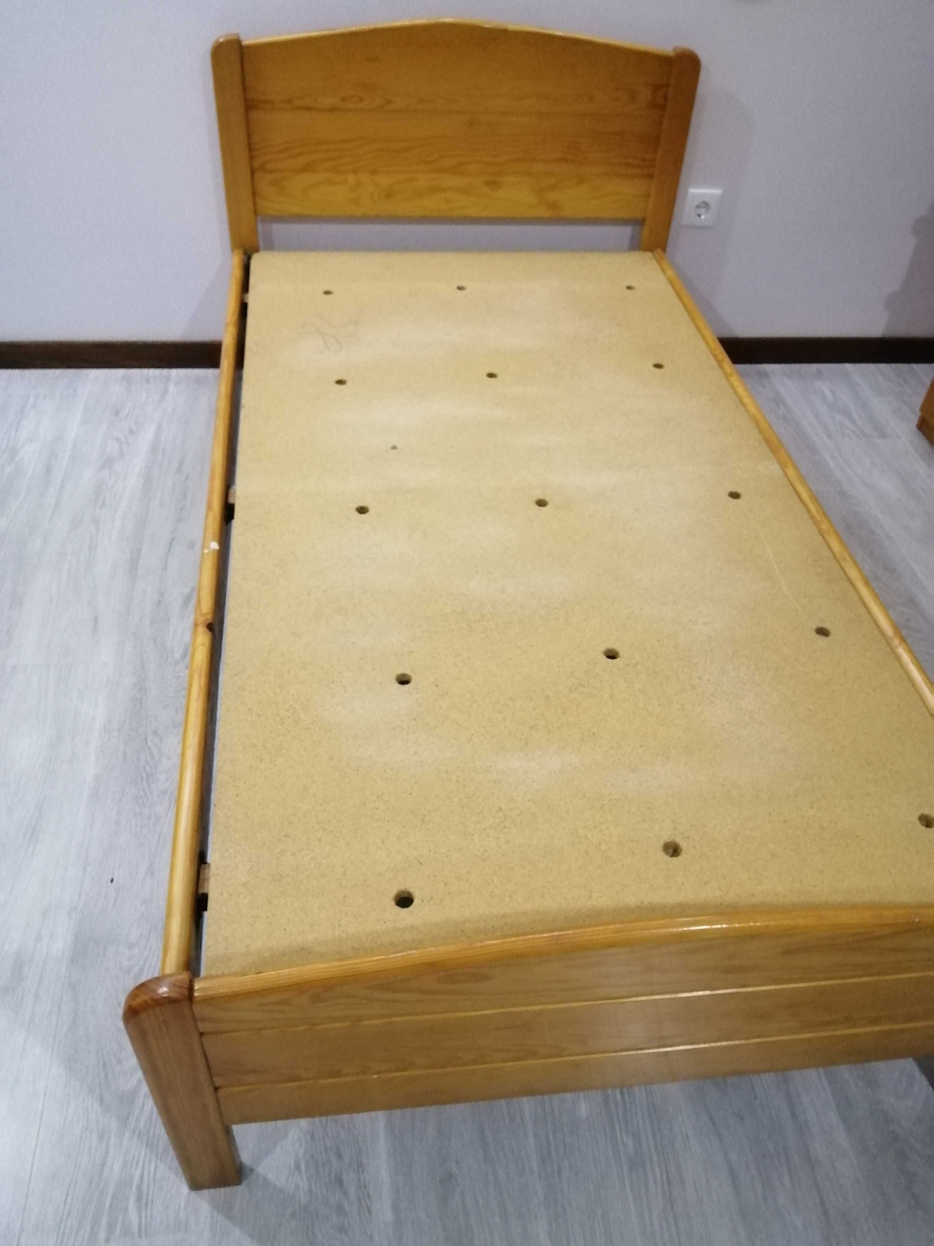 Cama de solteiro com mesinha de cabeceira.