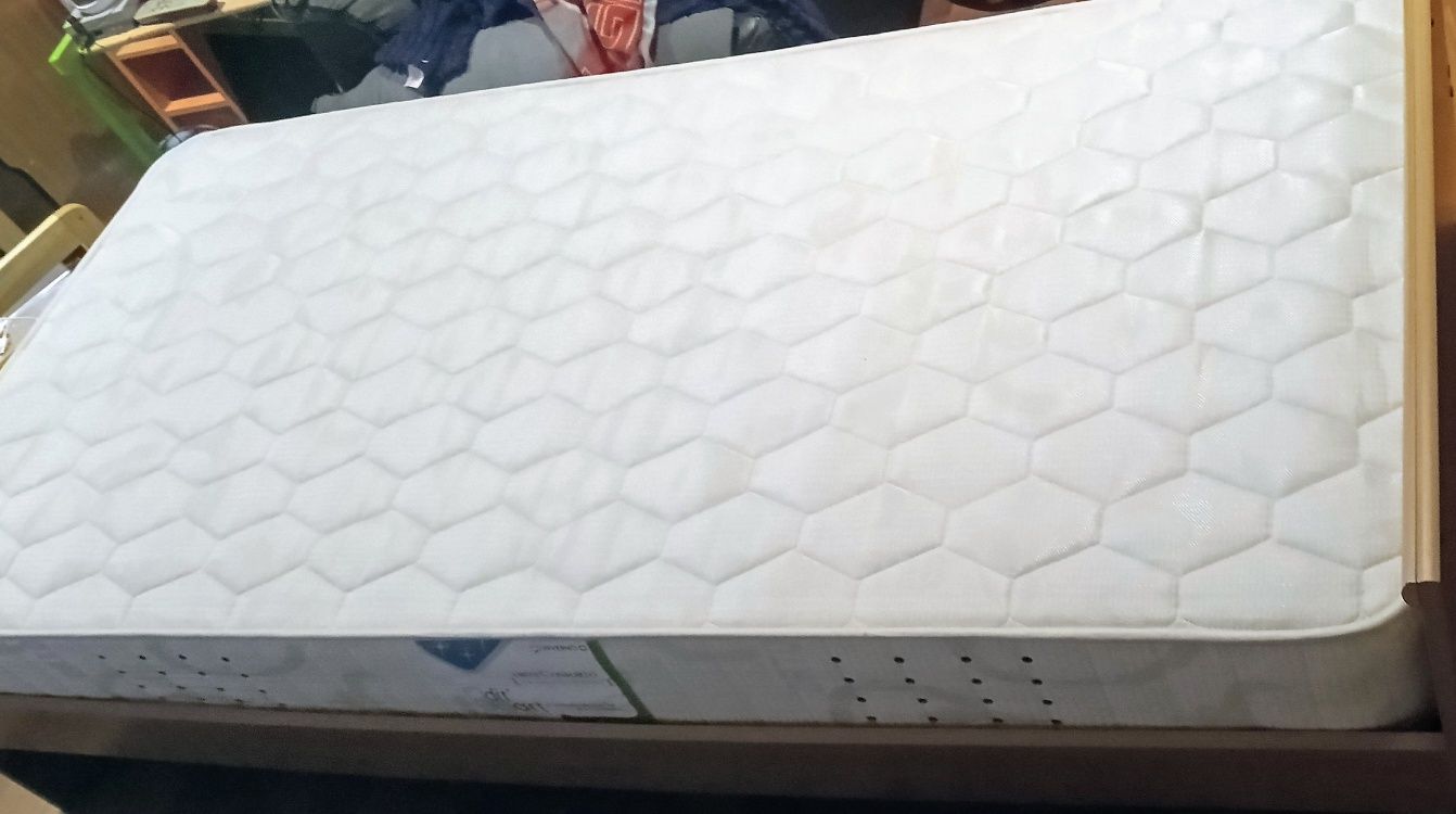 Cama solteiro com estrado, gavetas e colchão.