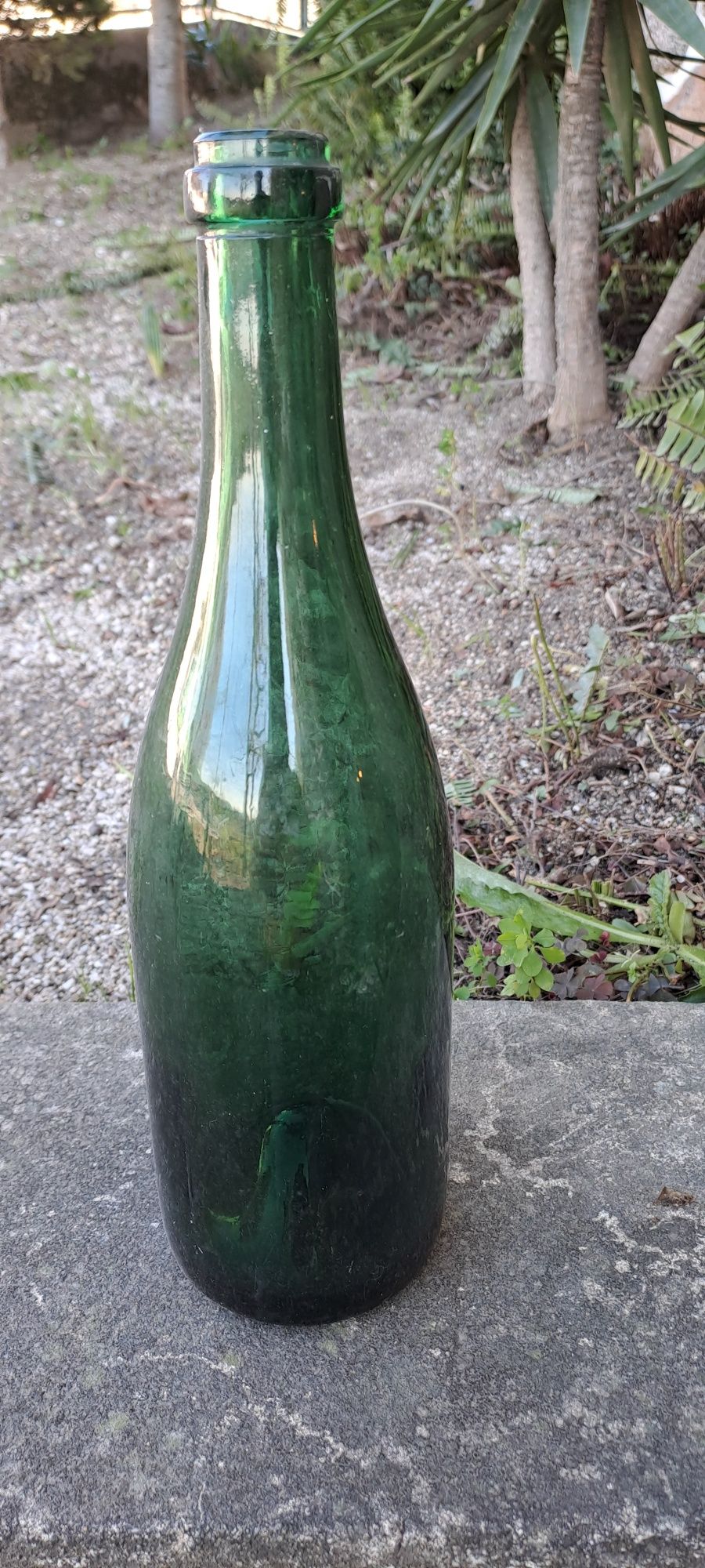 Garrafas de vidro verde e garrafeiras de barro