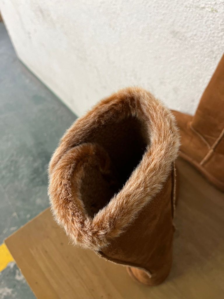 Botas beges com pêlo.