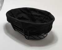 Metalowy koszyk na pieczywo z czarną tkaniną.