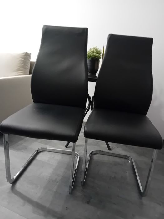 Eleganckie, czarne krzesła na metalowych, chromowanych nogach.