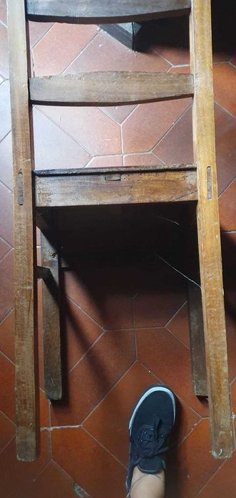 Cadeira antiga em madeira maciça, resistente e estável.