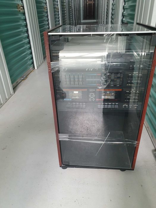Aparelhagem, com leitor de discos, leitor de cassetes, rádio e coluna.